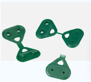 Green plastic rock climbing anchor plates with holes, laid on a white background.