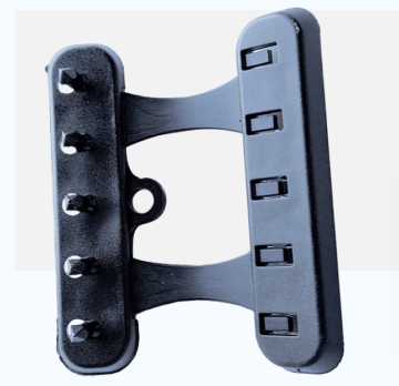 Two-piece metal guitar bridge/tremolo block with six saddles on the right and string ferrules on the left, connected by a curved central plate